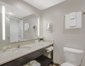 Private guest bathroom with shower and free toiletries at Days Inn & Suites By Wyndham Lindsay.