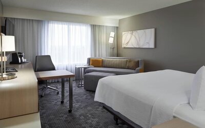 Bright day use room with TV, sofa, work desk and private bathroom at Courtyard By Marriott Toronto Airport.