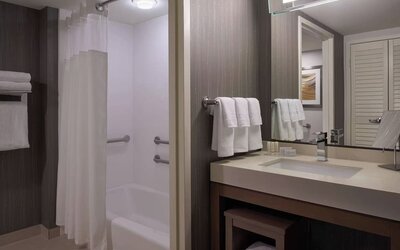 Private guest bathroom with tub and free toiletries at Courtyard By Marriott Toronto Airport.
