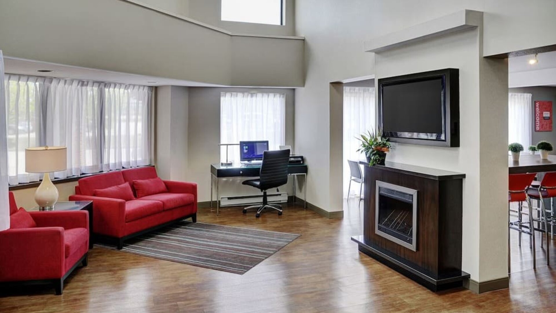 Lobby lounge area with fireplace and business center with computer, printer and ergonomic chair at Comfort Inn Sudbury Regent Street.