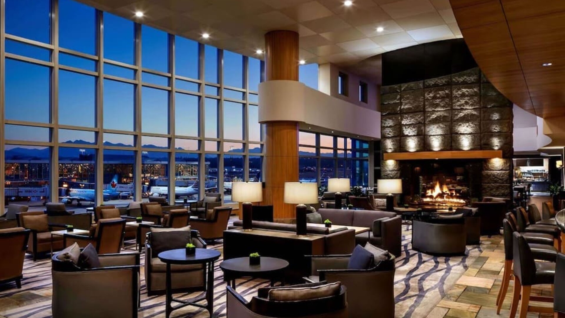 Hotel bar lounge area with fireplace at Fairmont Vancouver Airport - YVR Terminal Hotel.