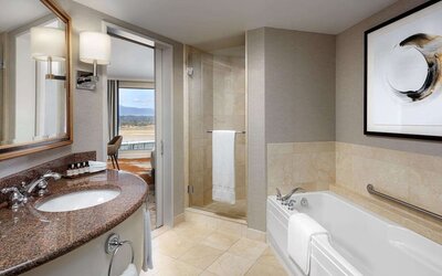 Private guest bathroom with shower and tub at Fairmont Vancouver Airport - YVR Terminal Hotel.