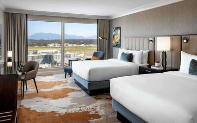 Bright and spacious day use twin room with TV, sofa, work desk and private bathroom at Fairmont Vancouver Airport - YVR Terminal Hotel.