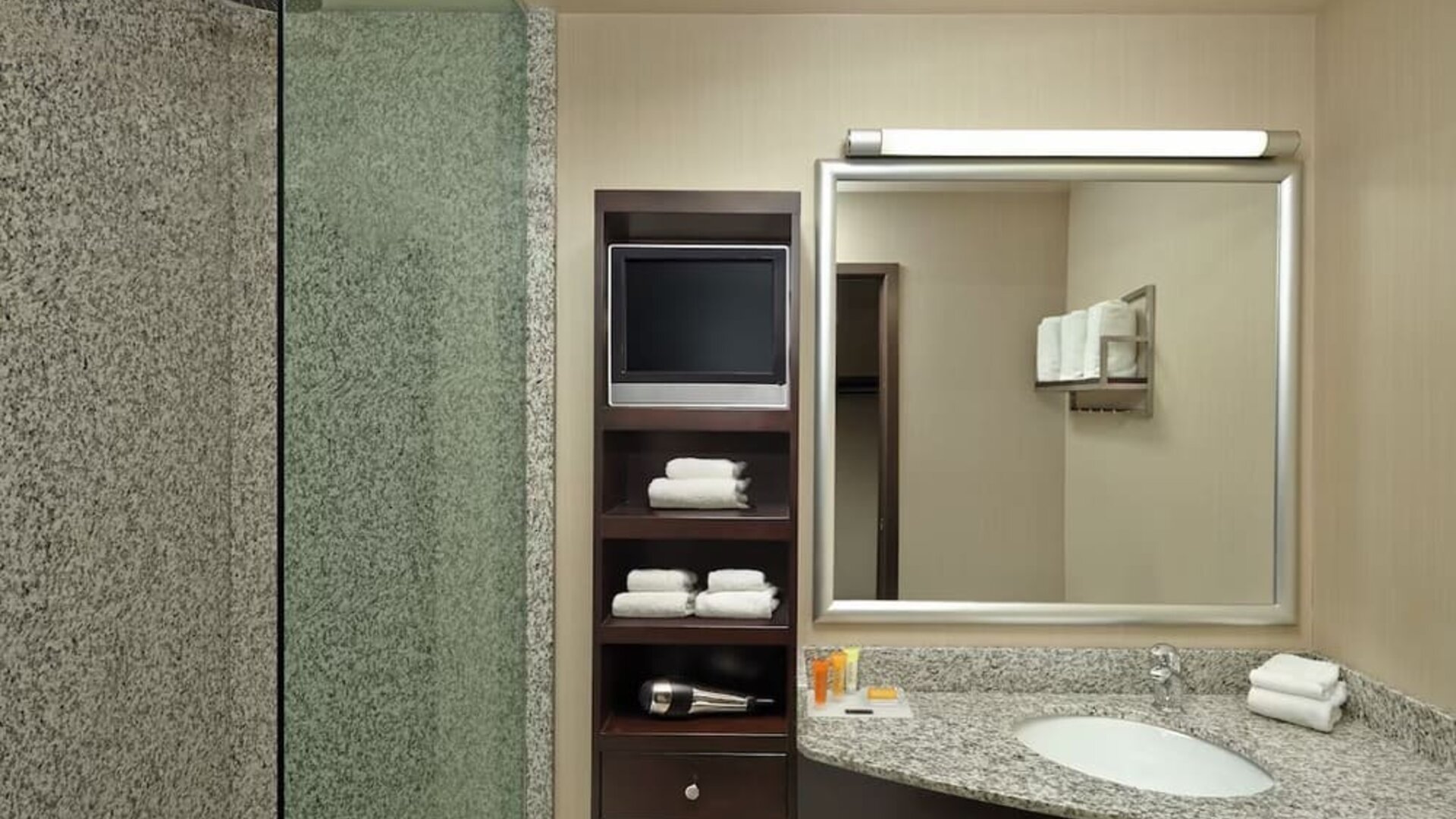 Guest bathroom with shower and free toiletries at Acclaim Hotel Calgary Airport.