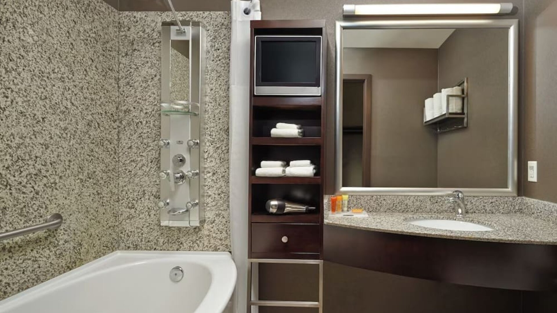 Private guest bathroom with tub, shower and free toiletries at Acclaim Hotel Calgary Airport.