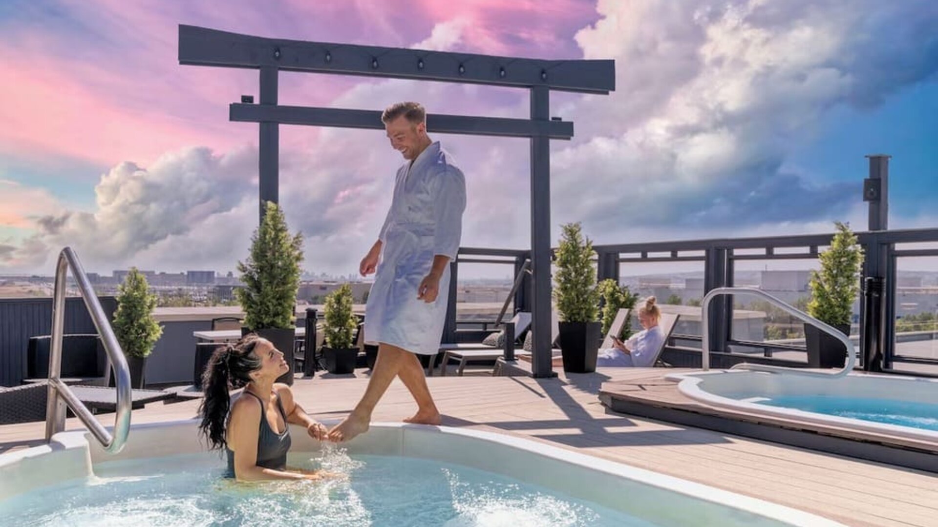 Hotel terrace with outdoor pool and hot tub at Acclaim Hotel Calgary Airport.