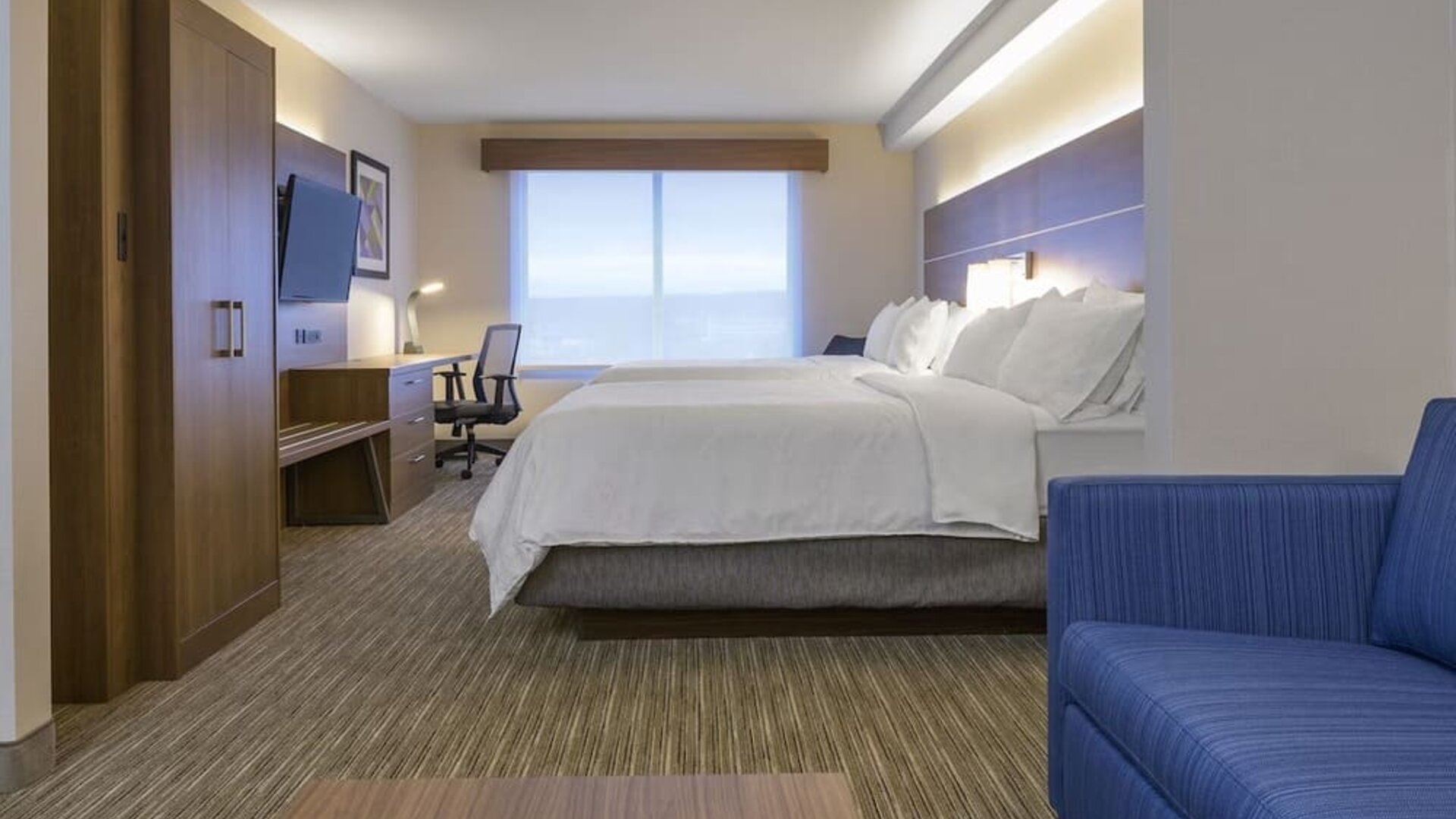 Day use room with TV, work desk, living area and private bathroom at Holiday Inn Express & Suites North Bay.