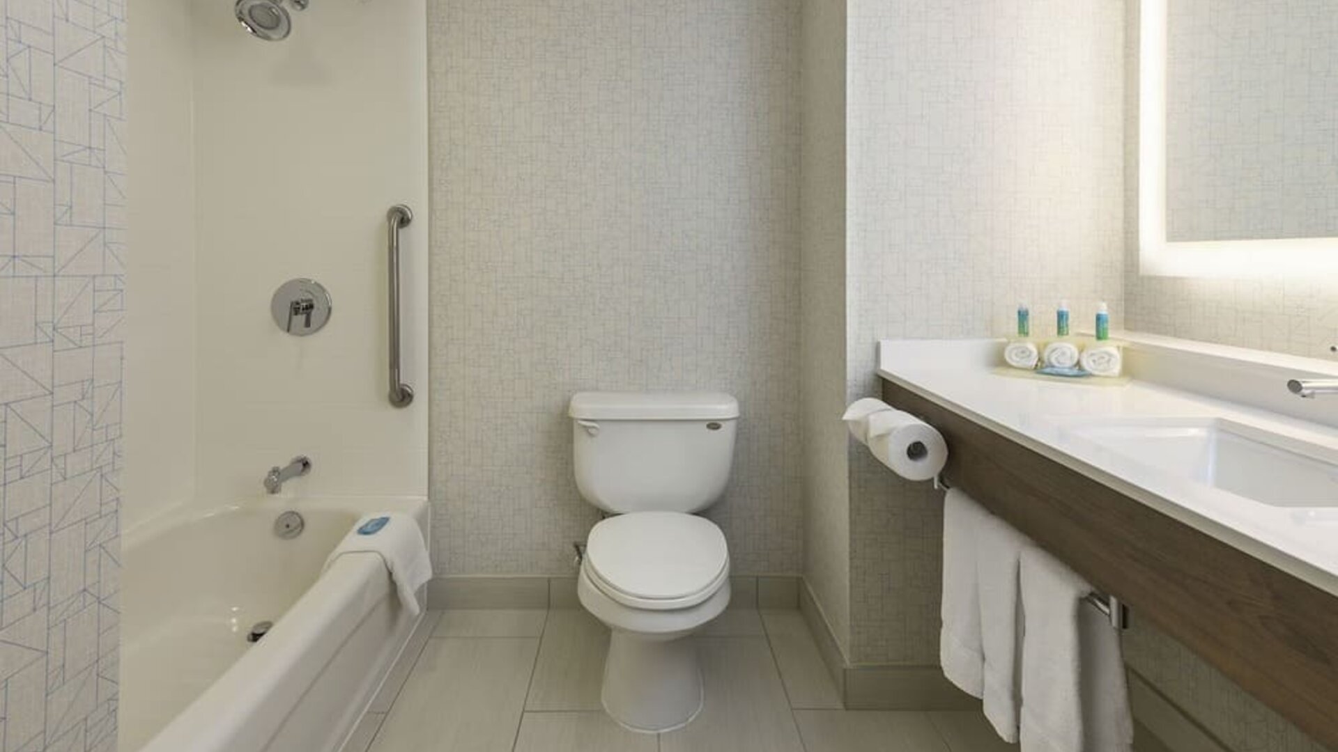 Guest bathroom with tub and shower at Holiday Inn Express & Suites North Bay.
