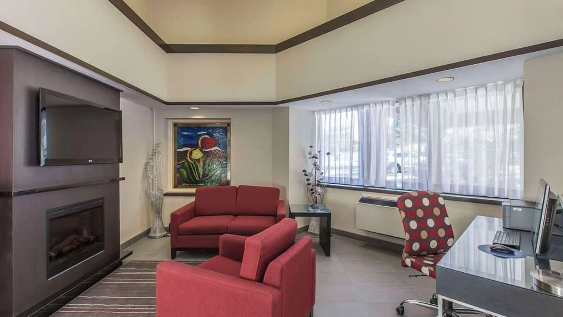 Hotel lobby with fireplace and worskpace with computer and printer at Comfort Inn Corner Brook.