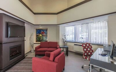 Hotel lobby with fireplace and worskpace with computer and printer at Comfort Inn Corner Brook.