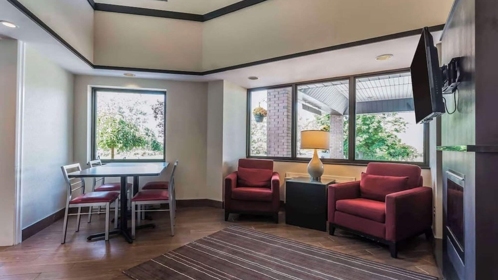 Lobby lounge with TV screen and fireplace at Comfort Inn Cobourg.