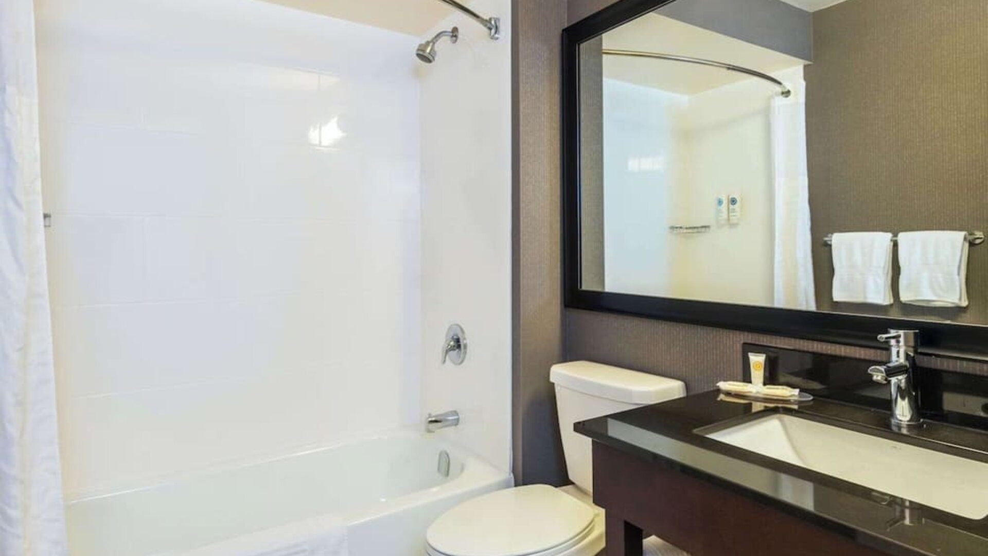Guesth bathroom with tub and shower at Comfort Inn Kingston HWY 401.

