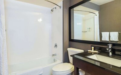 Guesth bathroom with tub and shower at Comfort Inn Kingston HWY 401.
