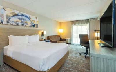 Standard day use room with TV, work desk, sofa and private bathroom at Comfort Inn Kingston HWY 401.