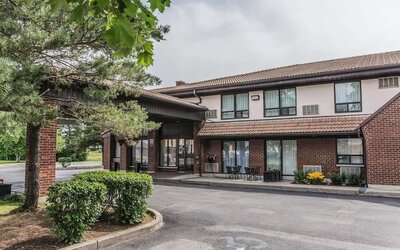 Hotel exterior with lounge area and parking at Comfort Inn Drummondville.
