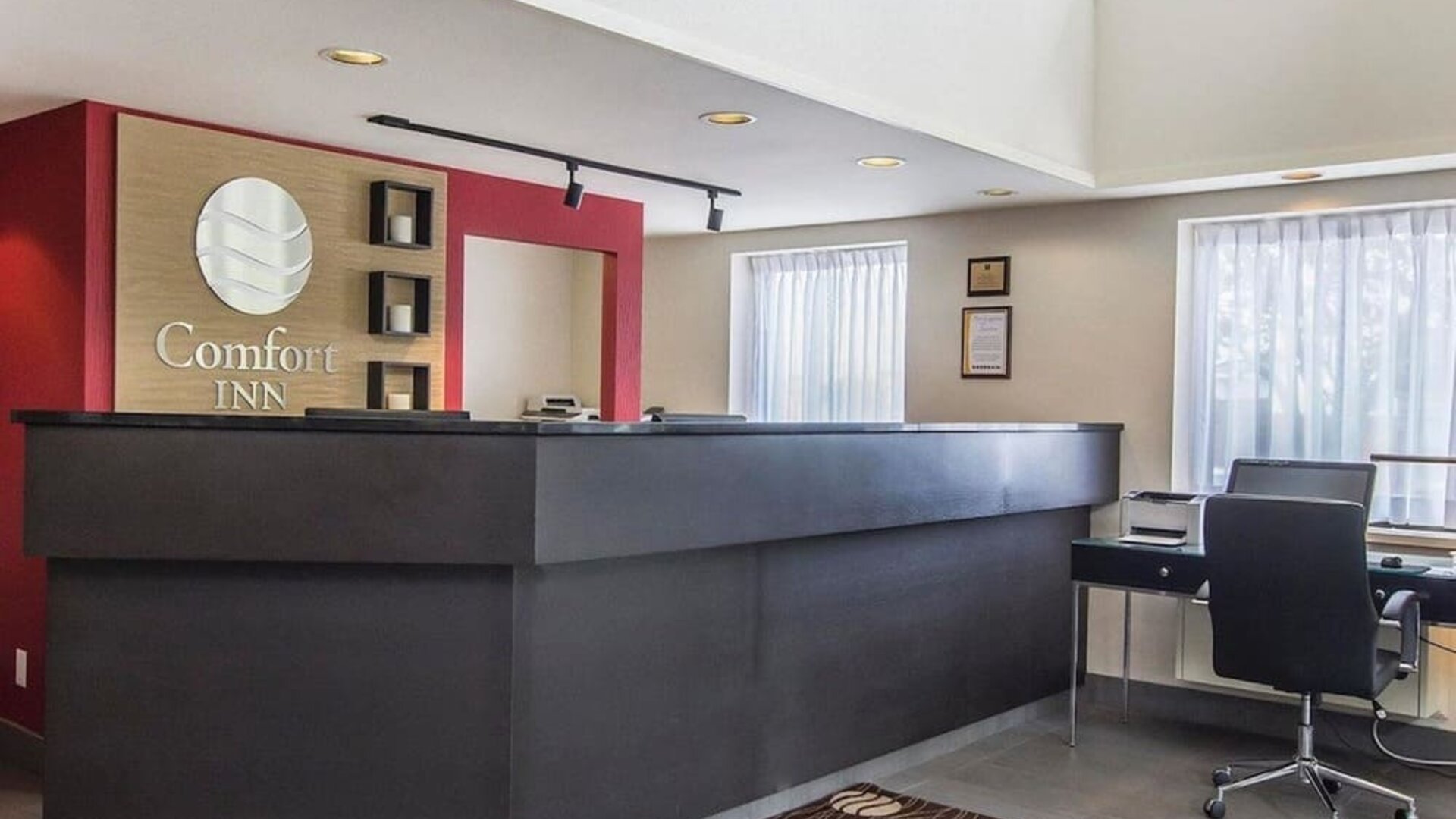 Hotel lobby with business desk with computer, printer and ergonomic chair at Comfort Inn Alma.