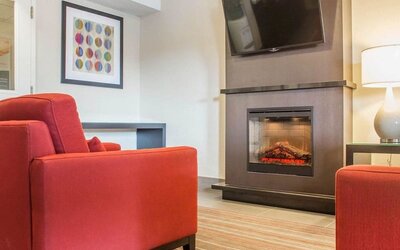 Lobby lounge with TV screen and fireplace at Comfort Inn Brantford.