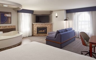 Day use suite with work desk, hot tub and living area with fireplace at Courtyard By Marriott Waterloo St. Jacobs.