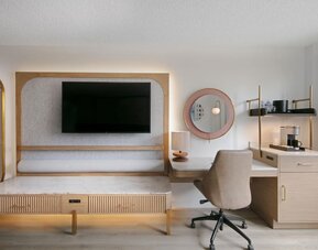 Day use room's workspace with TV screen and workdesk with ergonomic chair at Sonesta Miami Airport.