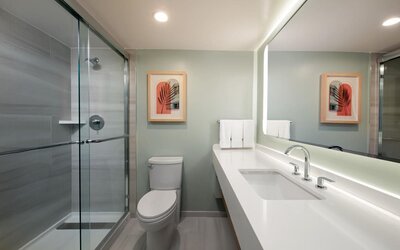 Private guest bathroom with shower and free toiletries at Sonesta Miami Airport.
