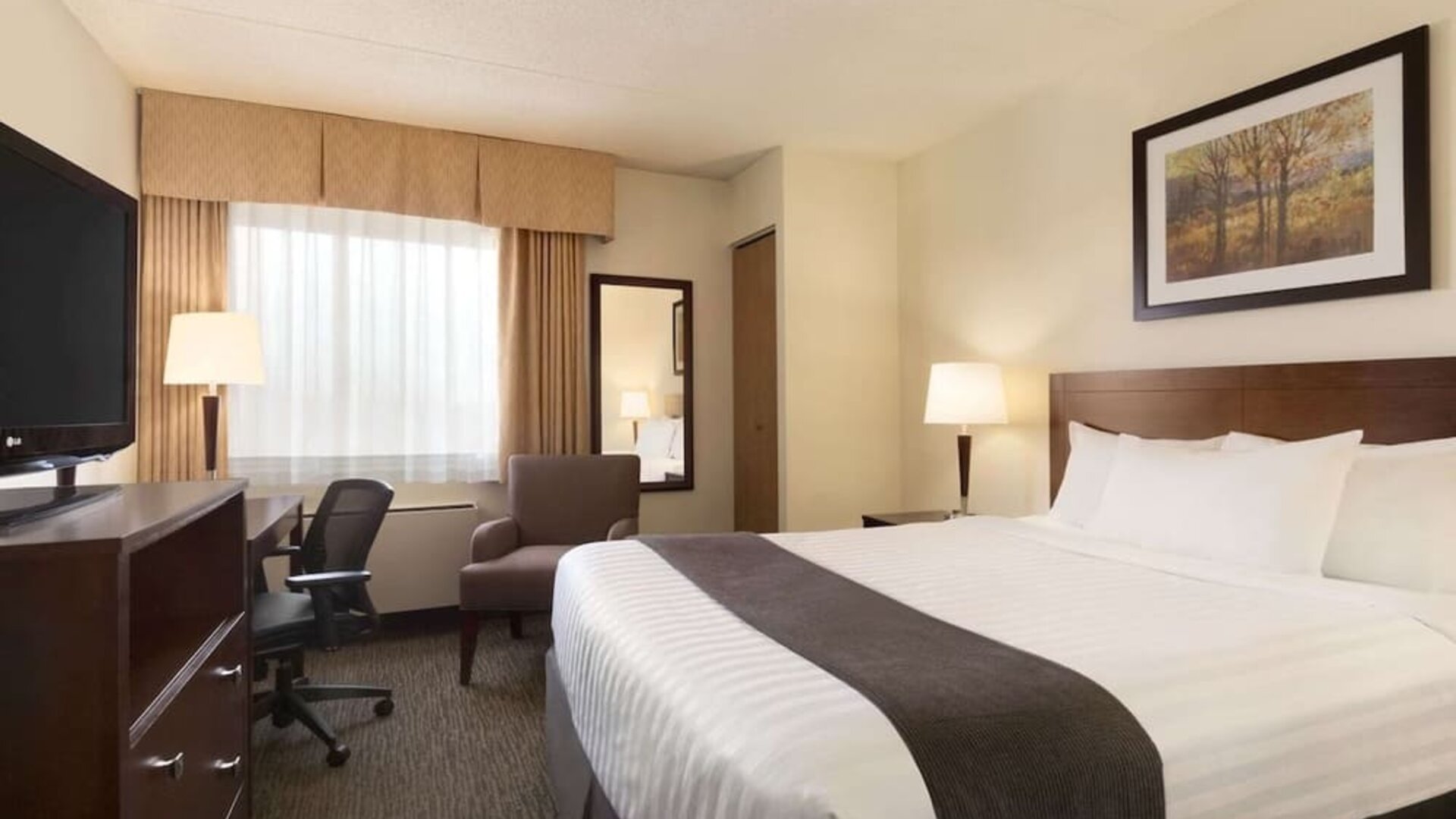 Standard day use room with TV, work desk, sofa and private bathroom at Travelodge Edmonton South.