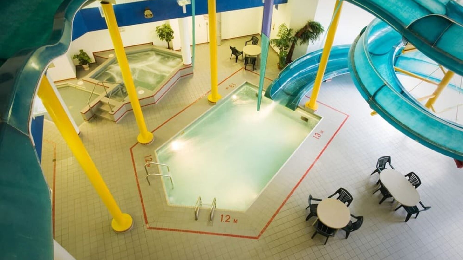 Indoor pool with spiral slide and jacuzzi at Delta Hotel By Marriott Regina.