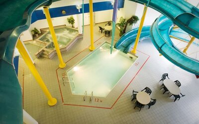 Indoor pool with spiral slide and jacuzzi at Delta Hotel By Marriott Regina.