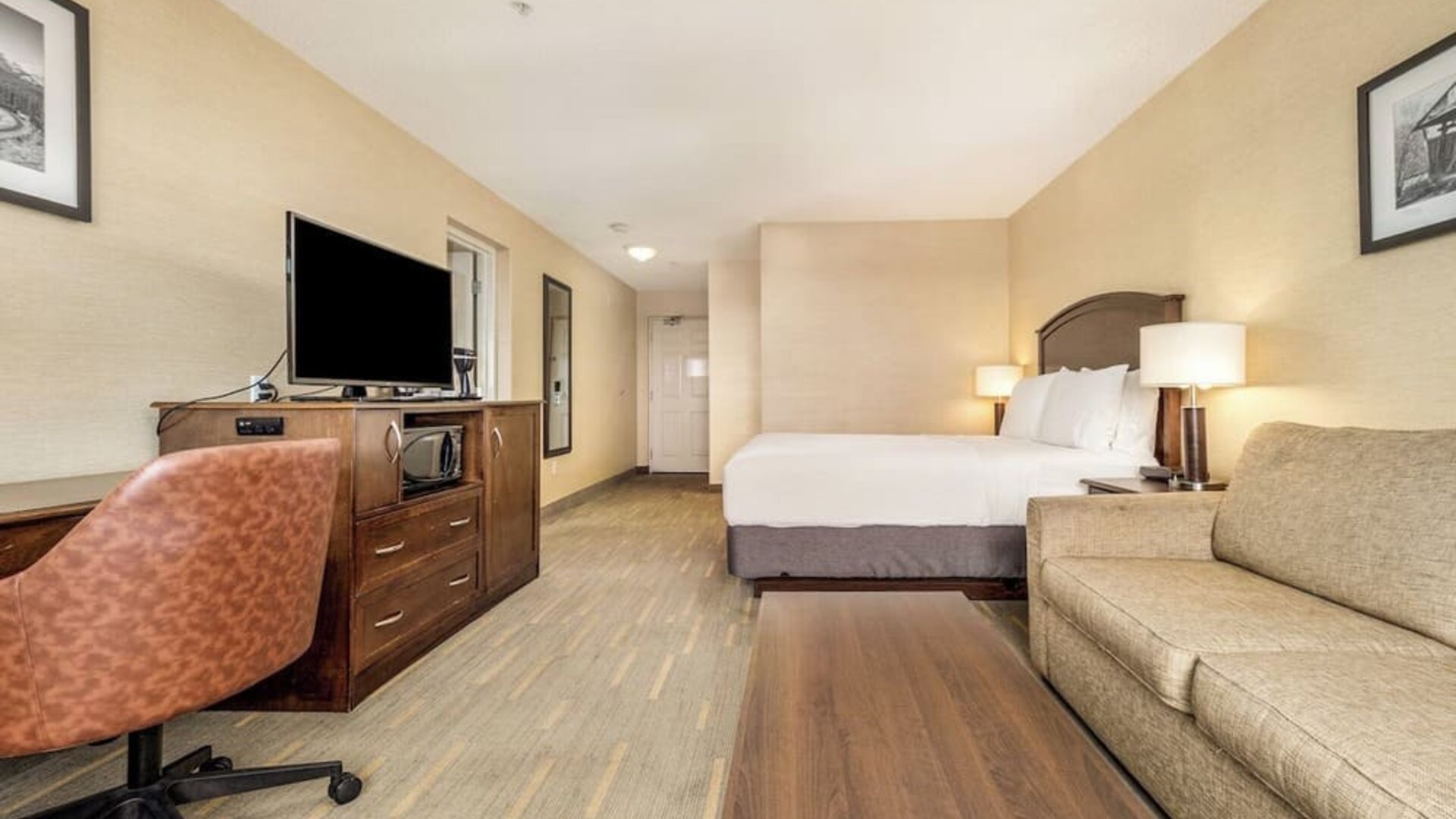 Day use room with TV, work desk and living area at Holiday Inn Lethbridge. 