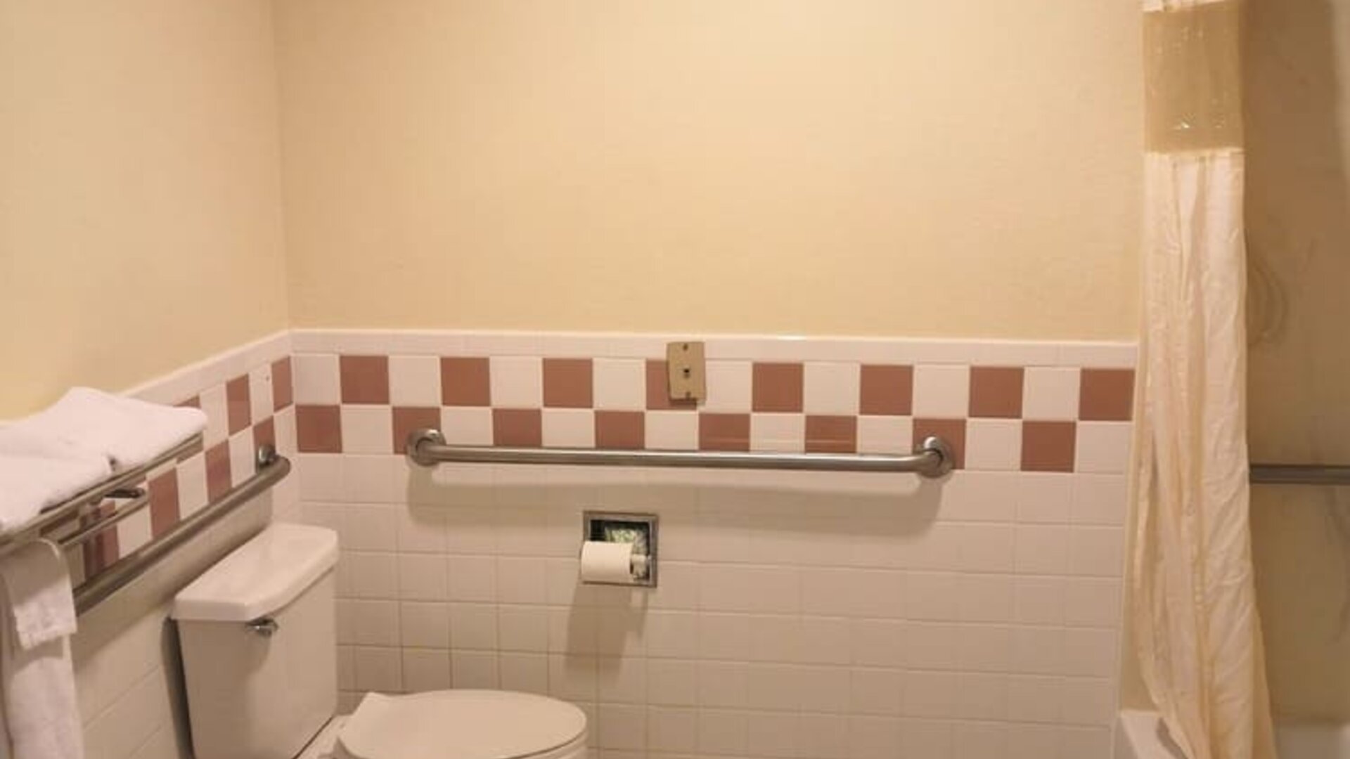 Guest bathroom with shower and tub at Scottish Inn & Suites.