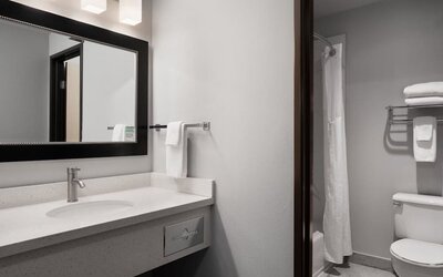 Guest bathroom with shower and tub at Garner By IHG.