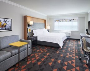 Day use room with TV, work desk and living area at Holiday Inn & Suites Oakville At Bronte.