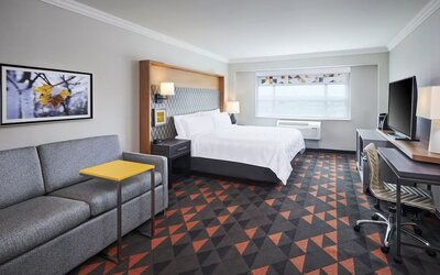 Day use room with TV, work desk and living area at Holiday Inn & Suites Oakville At Bronte.