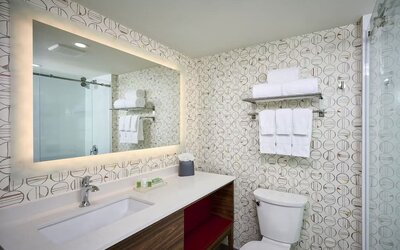 Guest bathroom with shower and free toiletries at Holiday Inn & Suites Oakville At Bronte.
