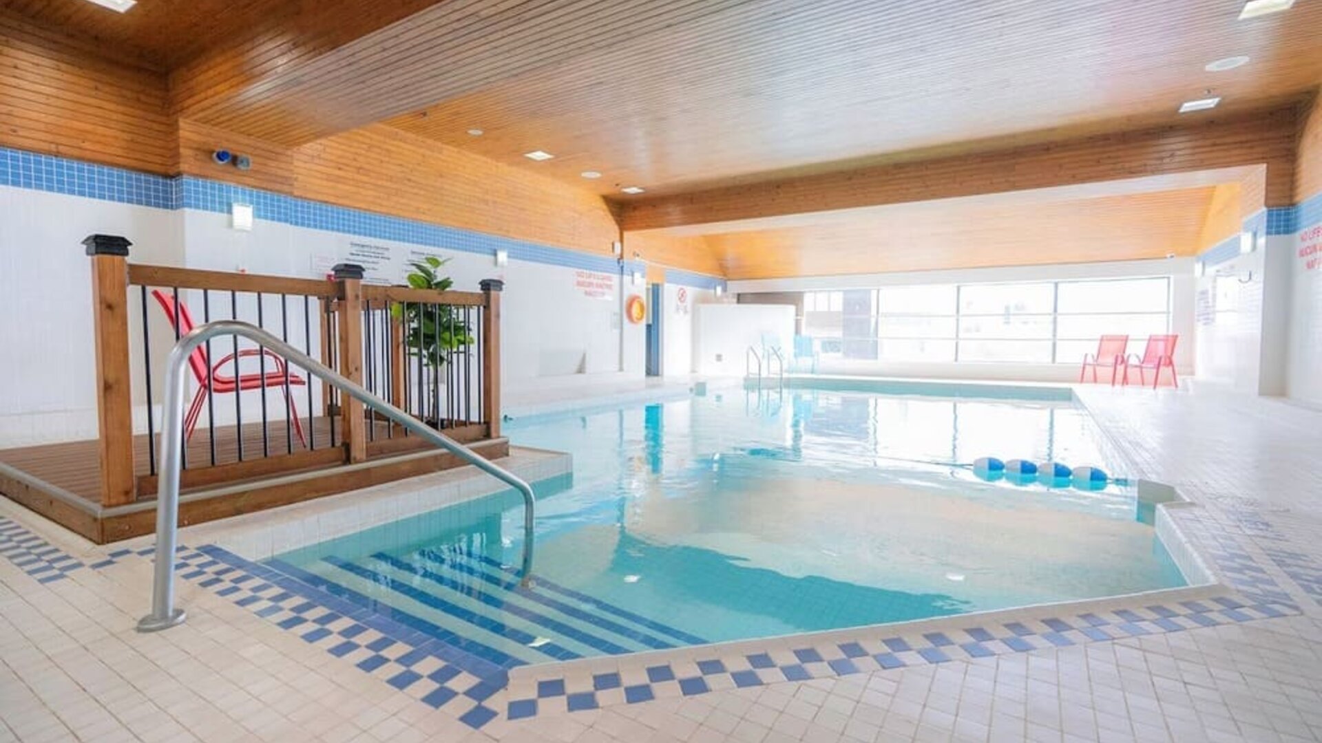 Relaxing indoor pool with lounge seating at Les Suites Hotel Ottawa.