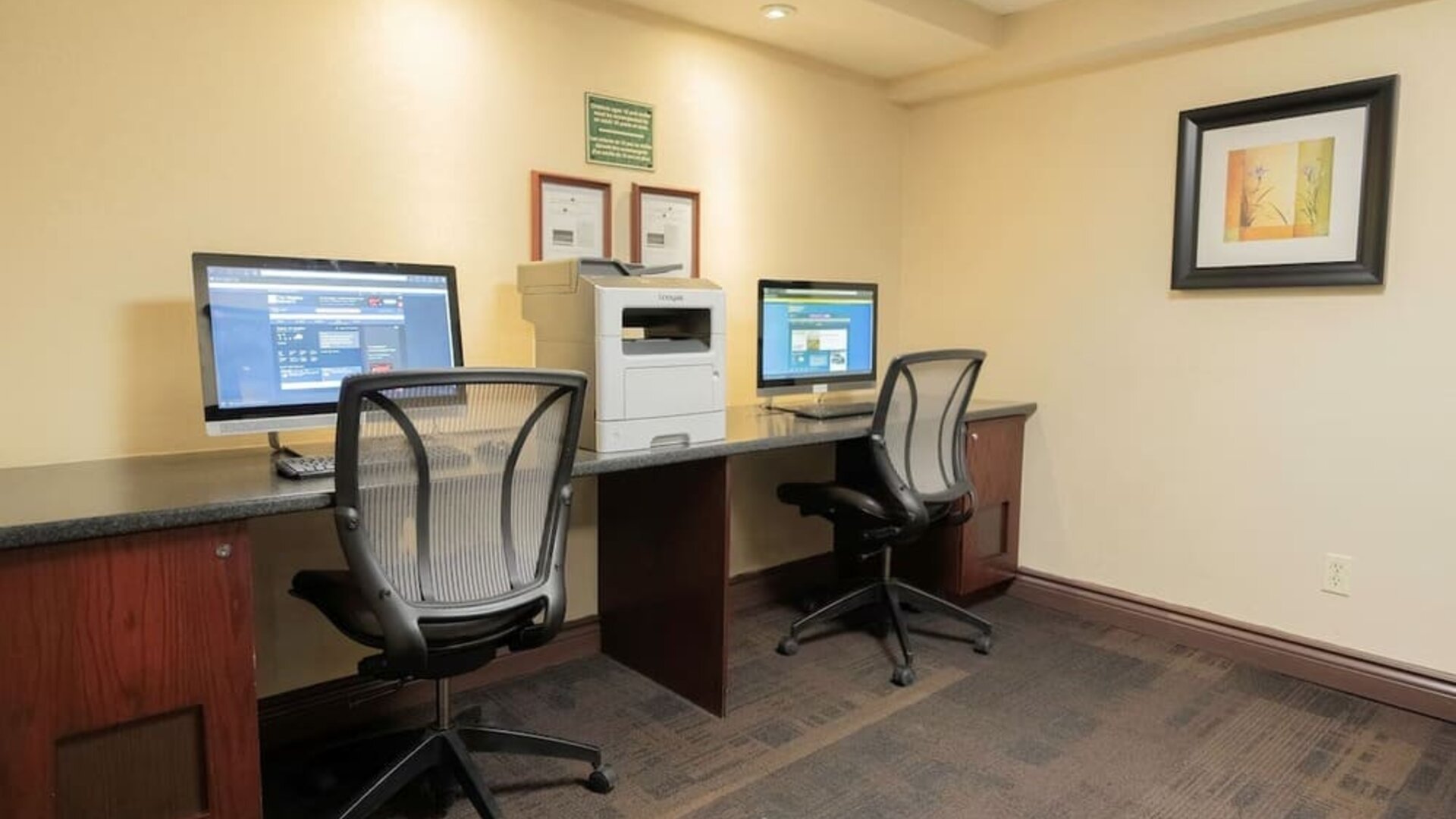 Business center with computers, printer and ergonomic chairs at Les Suites Hotel Ottawa.