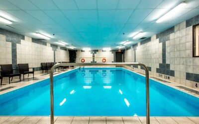 Indoor heated pool with lounge chairs at Halifax Airport Hotel.