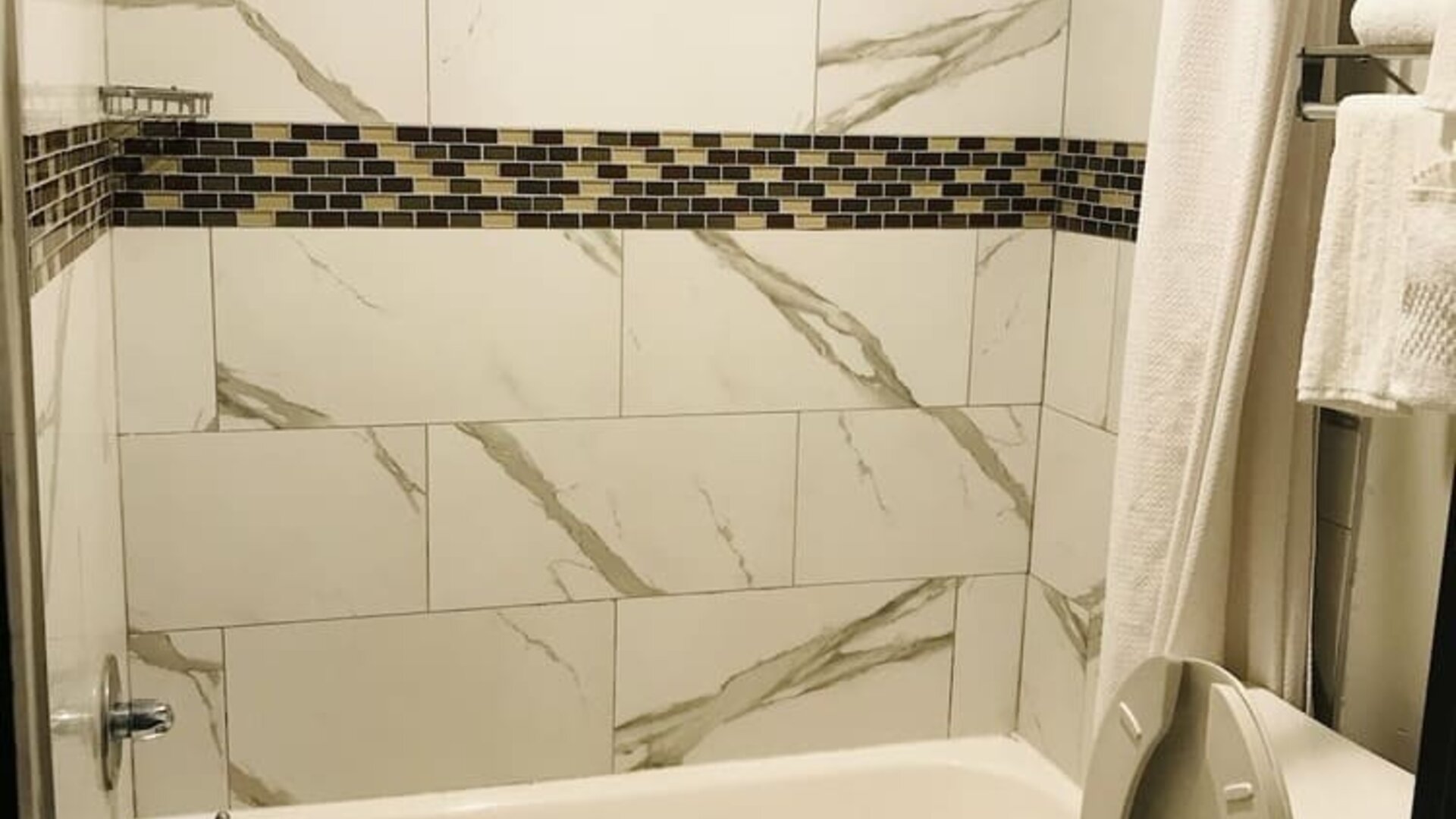 Guest bathroom with shower and tub at Summit Inn Near Houston Medical Center-NRG Park.