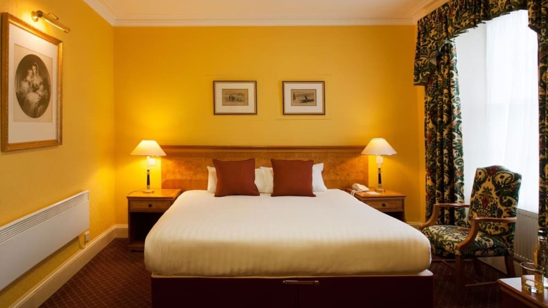 Single bed guest room in The Royal Highland Hotel, with bedside lamp and art on the wall.