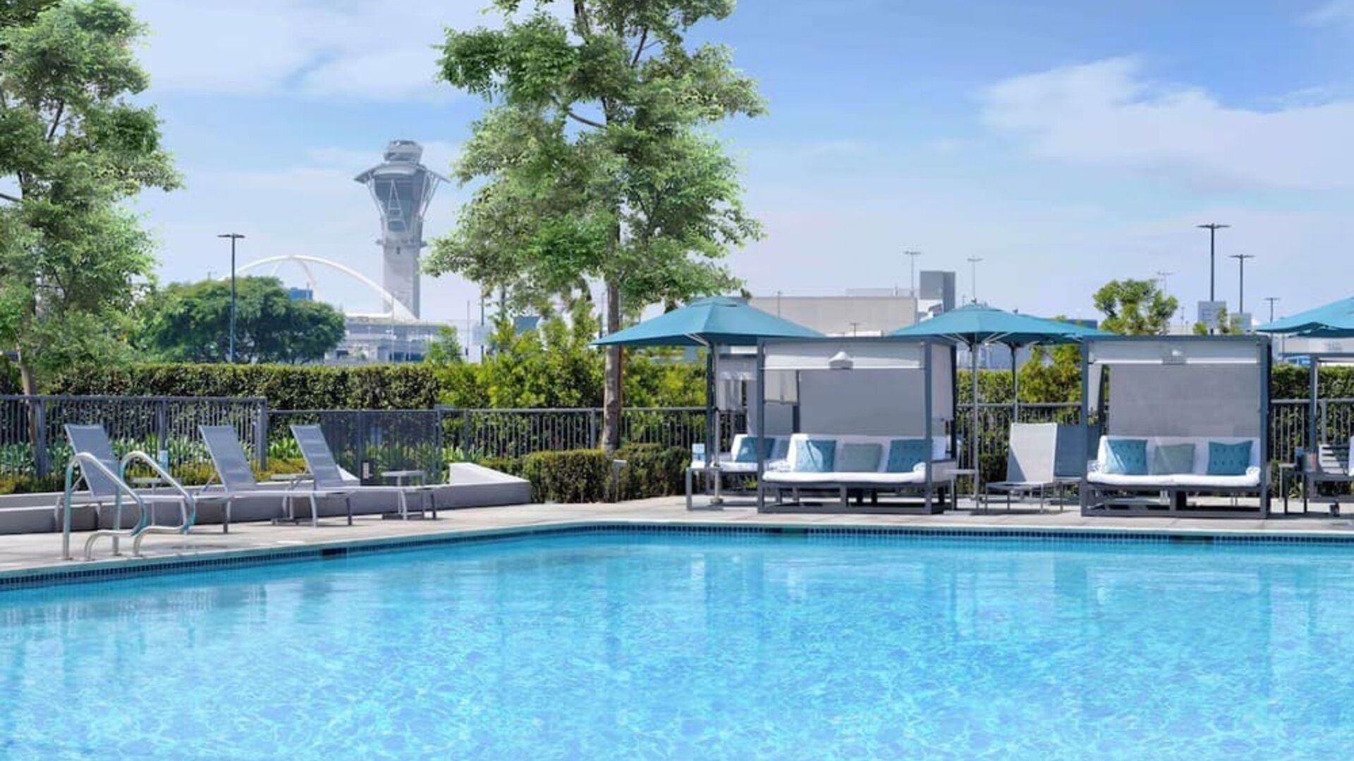 Refreshing outdoor pool with loungers and cabanas at Hyatt Regency Los Angeles International Airport.