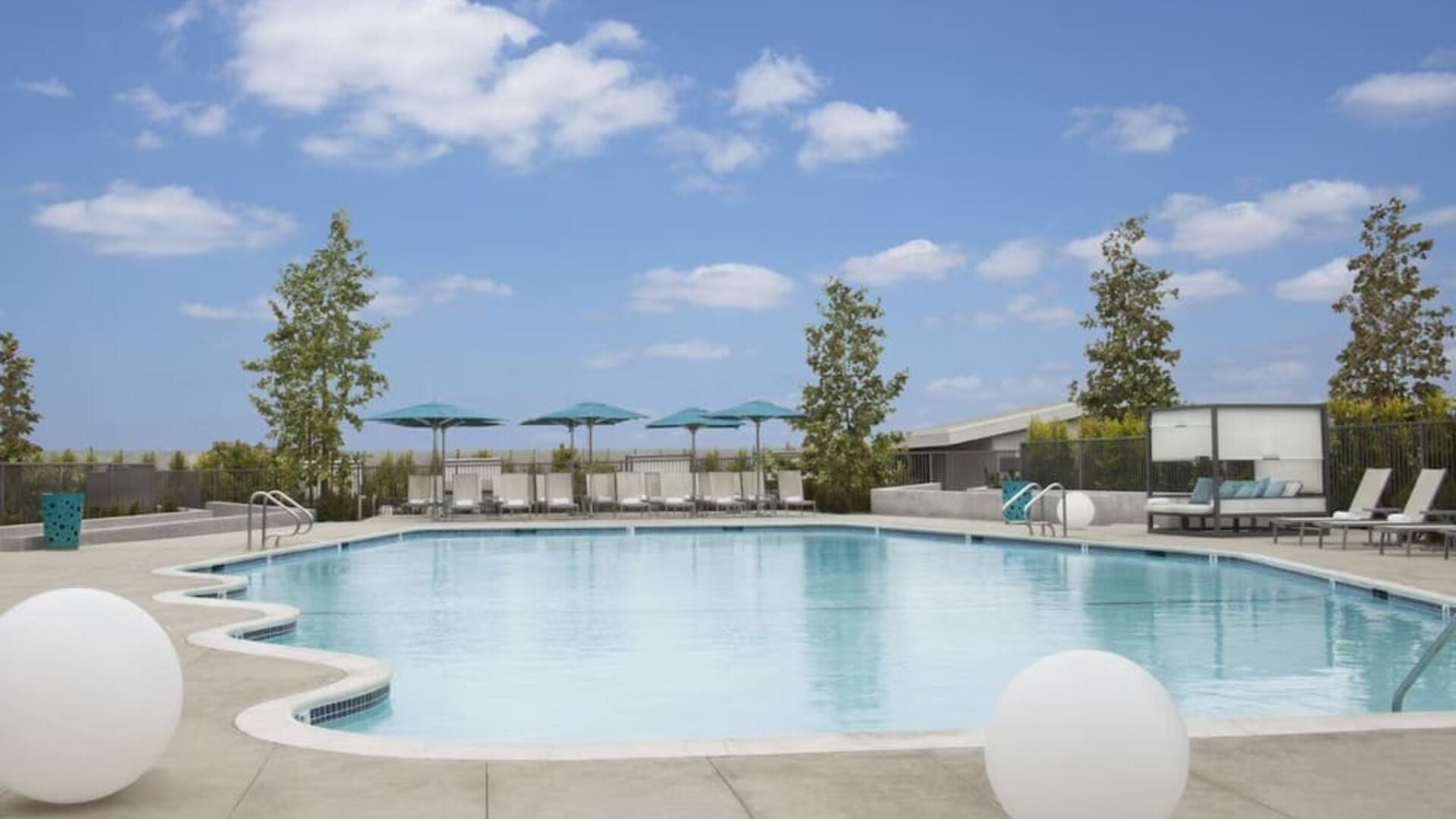 Refreshing outdoor pool with loungers and cabanas at Hyatt Regency Los Angeles International Airport.