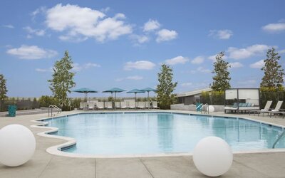 Refreshing outdoor pool with loungers and cabanas at Hyatt Regency Los Angeles International Airport.