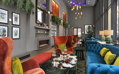Stylish lobby lounge with comfortable seating and fireplace at Leonardo Royal Hotel London Tower Bridge.