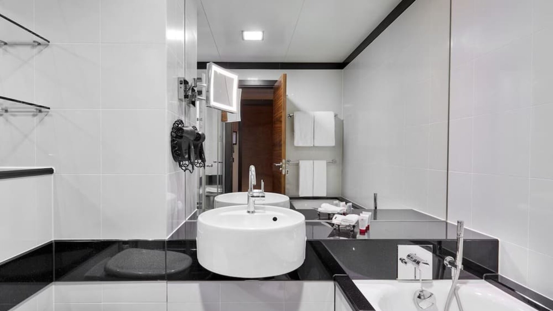 Private guest bathroom with separate shower and tub at Leonardo Royal Hotel London Tower Bridge.