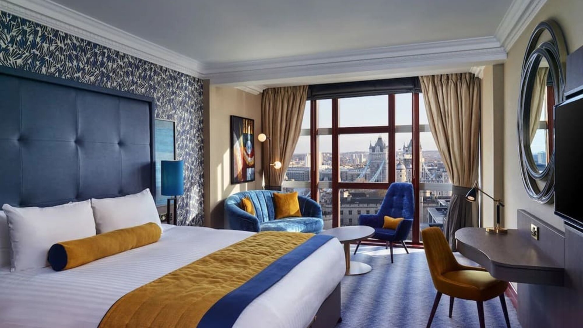 Day use room with work desk, lounge area and floor to ceiling window at Leonardo Royal Hotel London City.