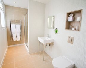 Guest bathroom with shower and free toiletries at The Wesley Euston Hotel.