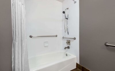 Guest bathroom with combined tub and shower at Hotel 1550 SFO.