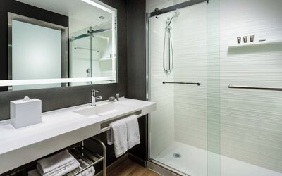 Guest bathroom with shower at AC Hotel By Marriott SFO/Oyster Point Waterfront.