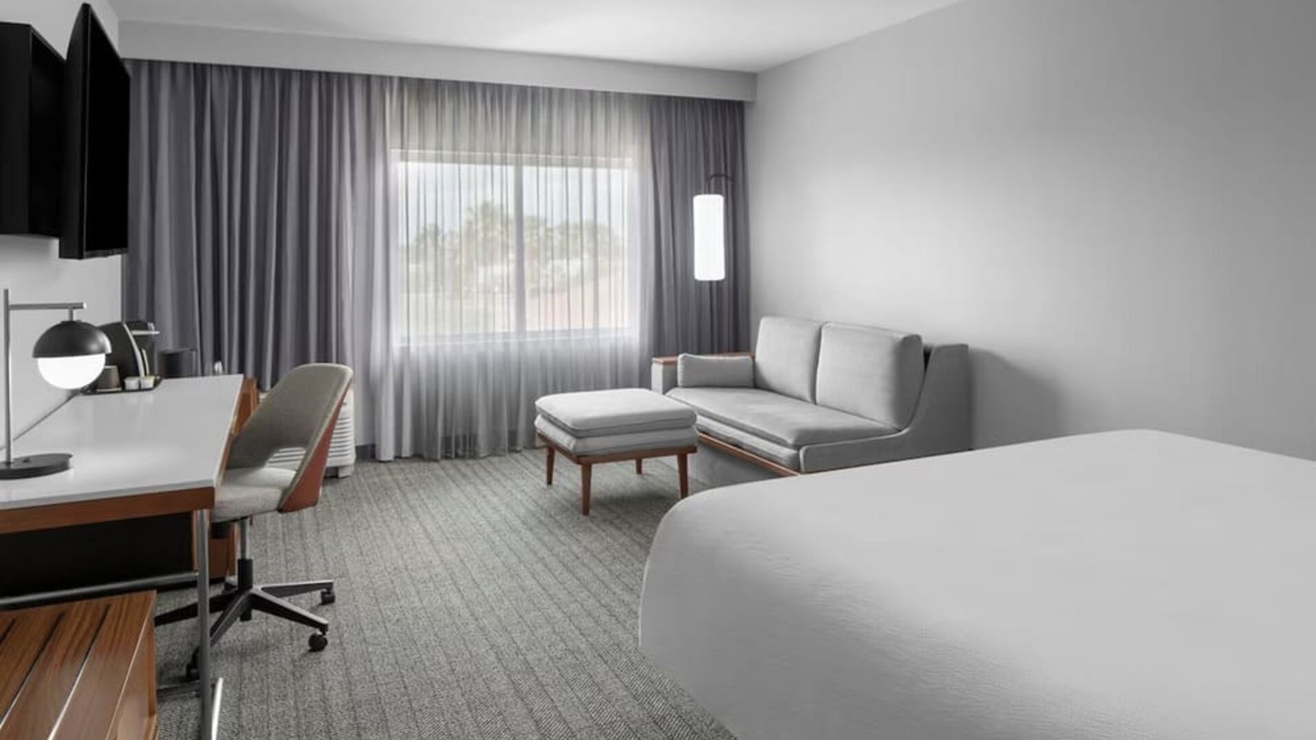 Spacious day use room with sofa and work desk at Courtyard By Marriott Tampa Oldsmar.
