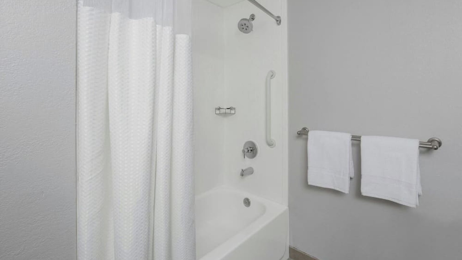 Guest bathroom with shower and tub at Courtyard By Marriott Tampa Oldsmar.