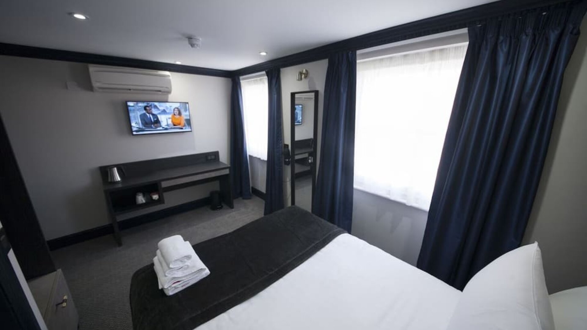 Bright and spacious day use room with TV screen and work desk at The Pack And Carriage London Hotel.